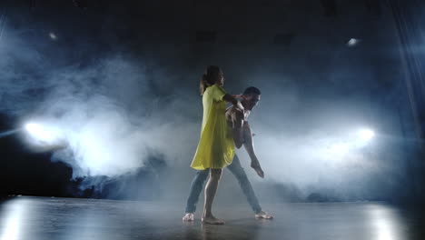 a-couple-is-dancing-fast-and-doing-acrobatic-tricks-in-slow-motion-on-stage-in-smoke-and-spotlights